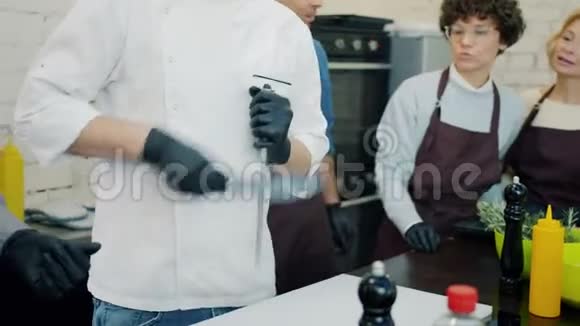 烹饪学校硕士班男厨师在厨房磨刀视频的预览图