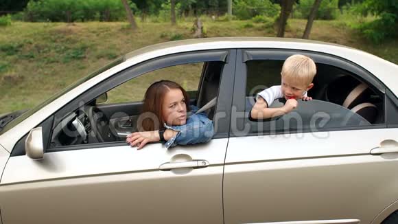 快乐的妈妈和小朋友在车里听音乐跳舞视频的预览图
