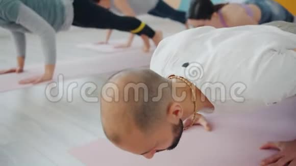帅哥在课堂上和一群喜欢练习的女人一起做瑜伽视频的预览图