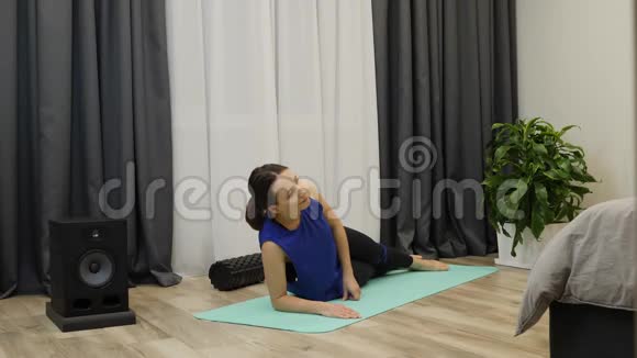 女人做侧木板集中女性在家里的垫子上做伸展瑜伽运动一位身材苗条的前男友做腹部锻炼视频的预览图