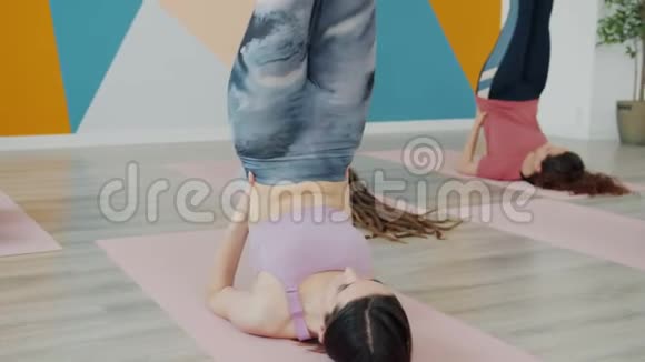 身材苗条的女人在工作室里做瑜伽铺着脚垫穿着运动服视频的预览图