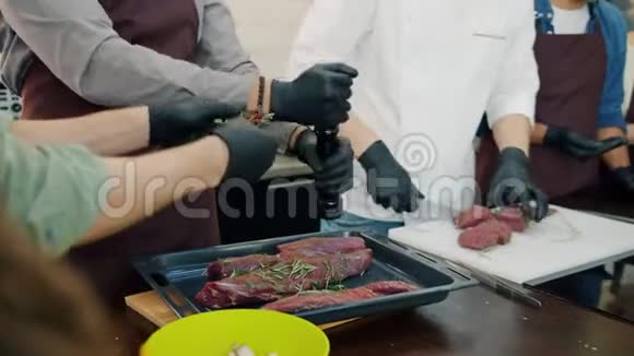 一队厨师穿着围裙和手套做肉菜专注于烹饪视频的预览图