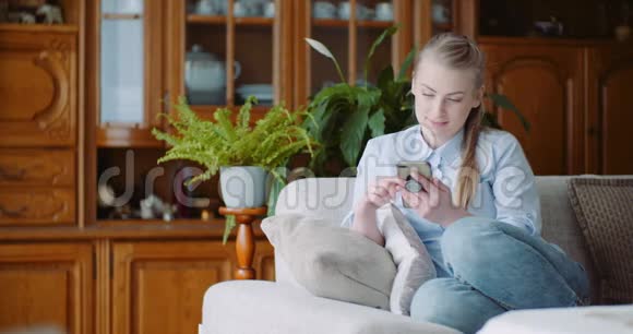 快乐的女人在家里浏览智能手机在家庭办公室工作的女商人视频的预览图