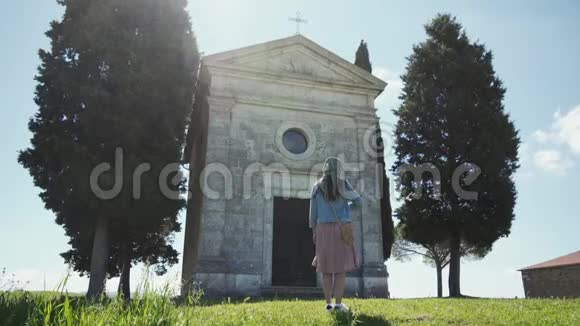 戴围巾的女人站在CappelladiVitaleta附近交叉自己拍摄时间长阳光明媚视频的预览图