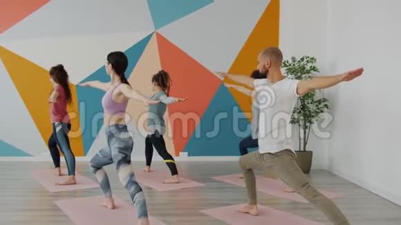 男人和女人一起在瑜伽馆做武士姿势练习视频的预览图