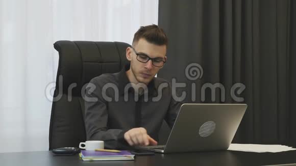 在现代办公室工作的商人专注的年轻人在工作场所工作坐在办公室里看手机屏幕的男人视频的预览图
