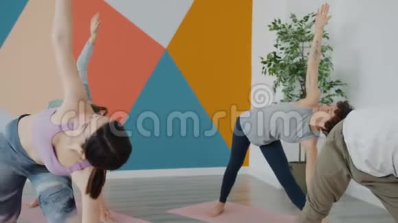 严肃的年轻人在室内运动瑜伽体式穿着紧身裤和上衣视频的预览图