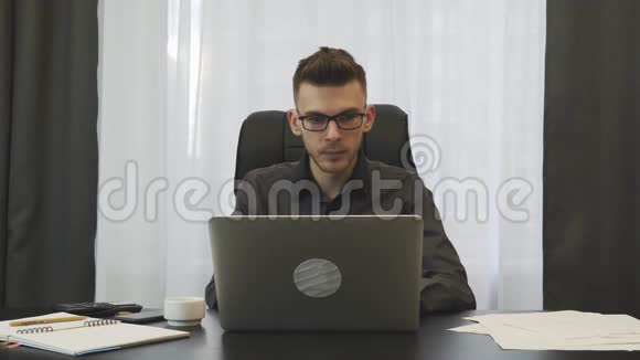 男人在现代办公室里坐在工作场所喝咖啡浓缩咖啡穿西装戴眼镜的年轻商人在办公室喝咖啡视频的预览图