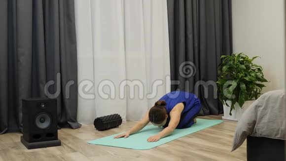 健身老师换瑜伽姿势年轻女性在明亮的房间里的垫子上做瑜伽女人向上向下表演视频的预览图