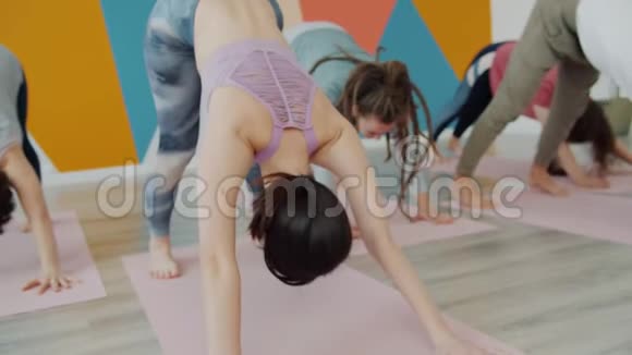 一群年轻人在瑜伽馆锻炼身体在垫子上伸展身体视频的预览图