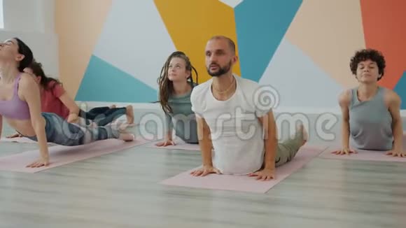 男子和妇女做瑜伽太阳敬礼和享受活动的慢动作视频的预览图