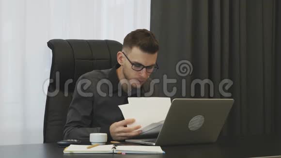 在办公室看公司财务报告的人年轻的成功商人在他的办公室里检查公司文件视频的预览图