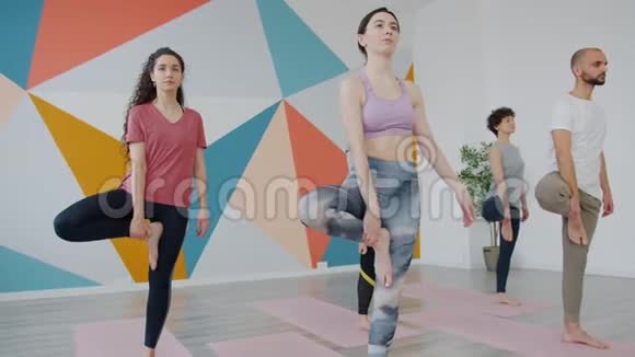 男女认真的人在工作室一只脚做瑜伽平衡视频的预览图