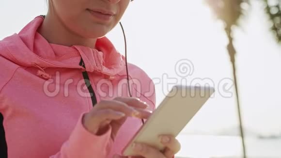 使用手机戴耳机的女性跑步者视频的预览图