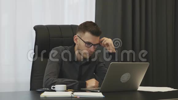 商人考虑他在现代办公室的工作人们为他在工作中的错误而烦恼自信的年轻男性在笔记本电脑上工作视频的预览图