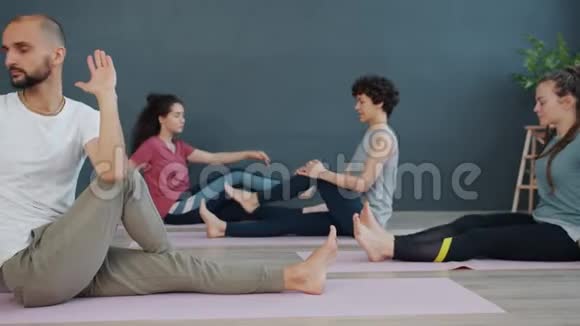 女孩和男人一起坐在灯光室里享受瑜伽练习视频的预览图