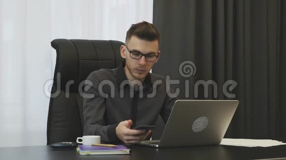 男人正在从现代办公室打电话成功的商人坐在办公桌前打电话年轻的微笑男视频的预览图