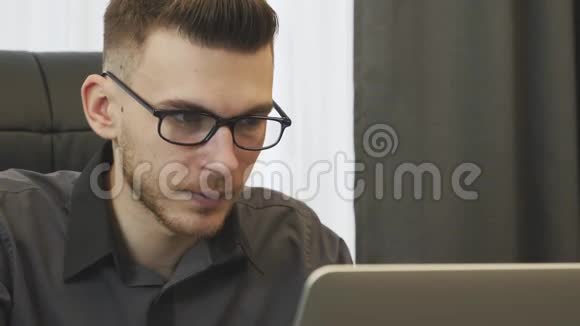 在笔记本电脑上工作的商人的肖像年轻人看着电脑屏幕特写男人看着笔记本电脑屏幕克隆视频的预览图