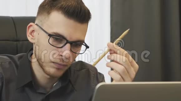 商人看着笔记本电脑屏幕关闭视野计算机屏幕上的人在网上阅读新闻的肖像男性顾问视频的预览图