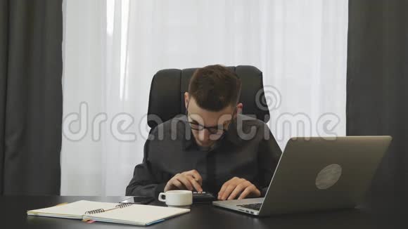 商人用笔记本电脑在现代办公室记账年轻男性会计检查财务报告年轻人做报告视频的预览图