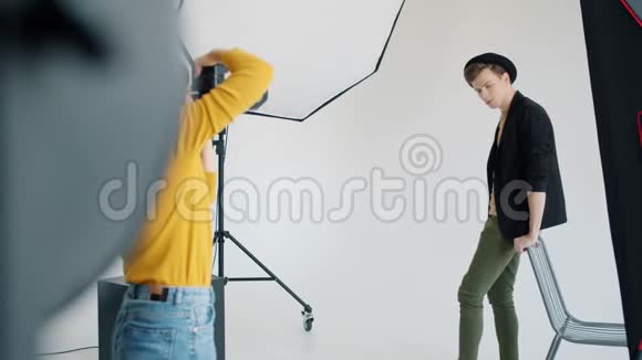 摄影棚中的男子模特在白色背景上摆姿势视频的预览图