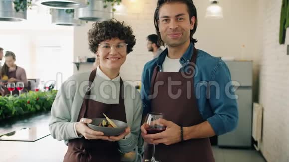 烹饪课上男女慢镜头肖像手捧食物微笑喝酒视频的预览图