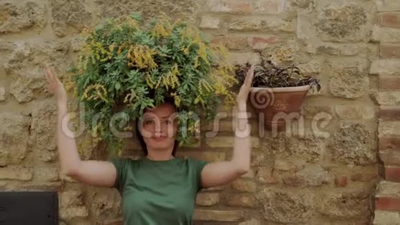 美丽的女人用绿色的花代替头发不寻常的趣味春景视频的预览图