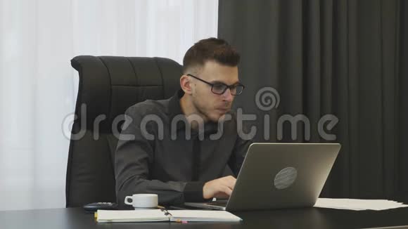 穿西装戴眼镜的商人在他的现代办公室工作成功的男人在工作场所工作男性电脑顾问视频的预览图