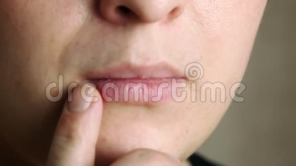 嘴唇特写的声音一个女人用手指摸伤口视频的预览图