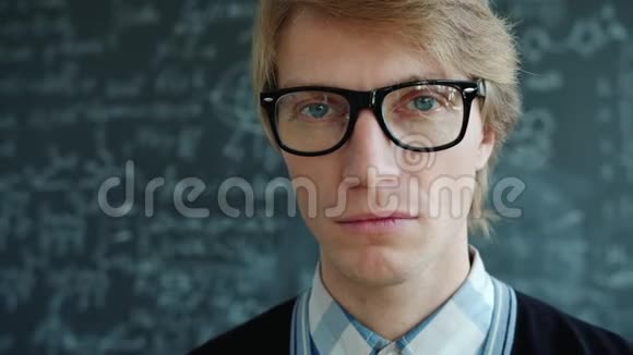一幅严肃聪明的男人戴着眼镜看着室内摄像机的特写肖像视频的预览图