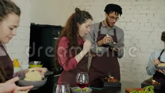 一群快乐的男人和女人在烹饪大师级之后吃着美味的饭菜视频的预览图
