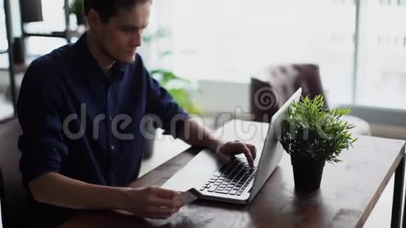 商人在笔记本电脑上输入信用卡信息进行在线购买视频的预览图