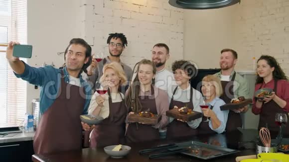 男人和女人拿着食物和饮料在烹饪大师级后用智能手机自拍视频的预览图