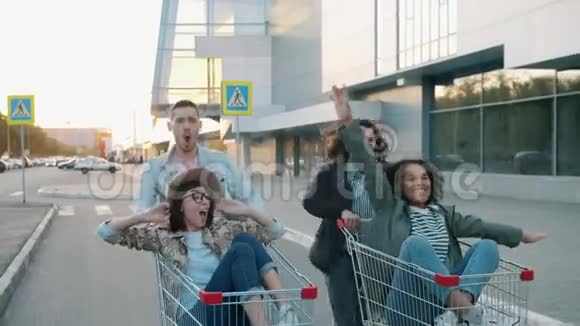 学生们在外面骑着购物车一起做着击掌大笑视频的预览图