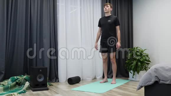 伸展腿部肌肉的人年轻的运动男性在室内做健身和有氧运动穿黑色运动服的运动员担架视频的预览图