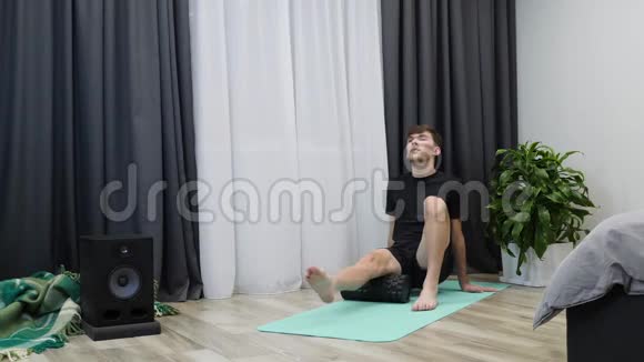 男人做臀肌按摩与筋膜滚动运动衣的男运动员在经过艰苦的训练后进行康复锻炼视频的预览图