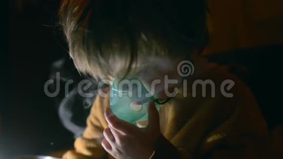 白种人小男孩在夜间通过雾化器呼吸视频的预览图