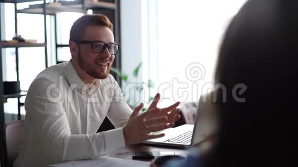 有眼镜和胡子的英俊男经理正在咨询客户视频的预览图