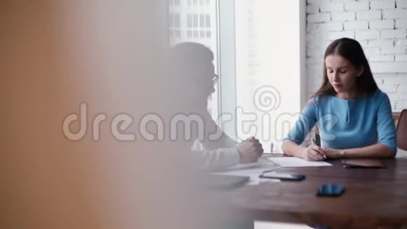 老板是一个年轻的女人在公司员工面前在纸上做笔记视频的预览图