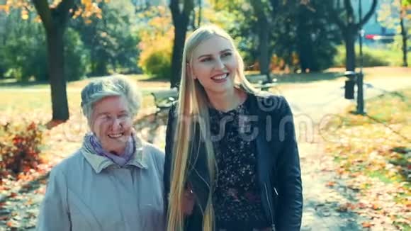 老女人和漂亮的年轻女人在公园散步时拥抱在一起视频的预览图