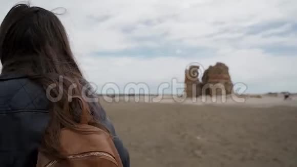 旅游女孩带着背包接近意大利拉迪斯波利的一座古老堡垒的废墟后视图视频的预览图