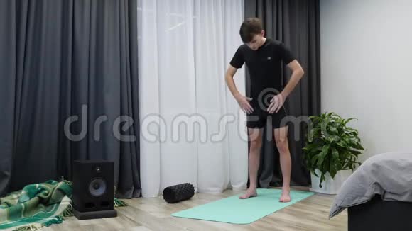 做体育锻炼的人英俊适合男性伸展在瑜伽垫穿运动服装的白种人运动男孩伸展肌肉视频的预览图