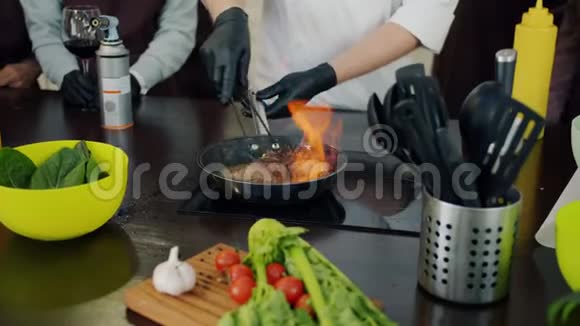 锅上的煎锅和用火煮的肉片视频的预览图