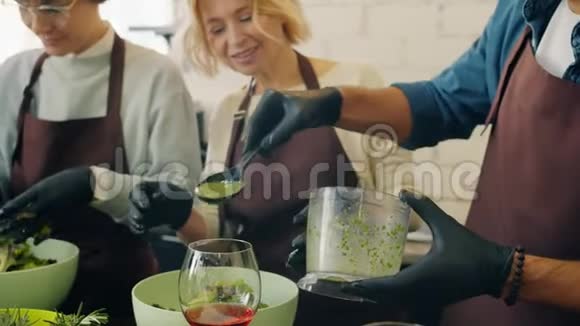 在烹饪课上做菜的男人和女人一起工作享受业余爱好视频的预览图