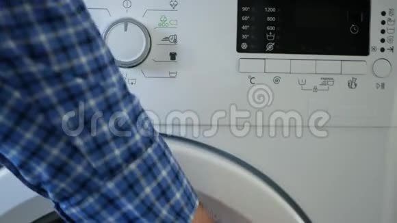 男士将脏衣服放入洗衣机设定程序并开启电源视频的预览图