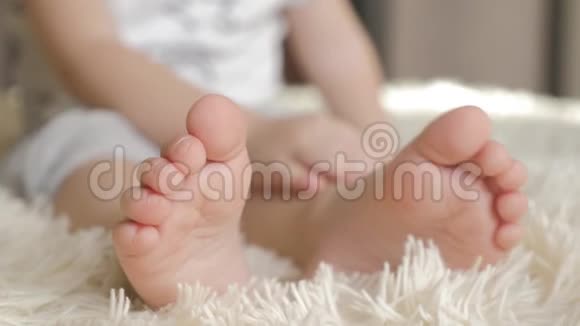宝宝脚踩床上一条白色毯子特写视频的预览图