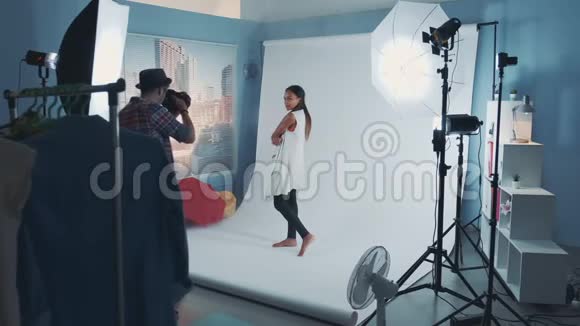 图片拍摄后台年轻的非洲模特在现代工作室的白色背景下摆姿势视频的预览图