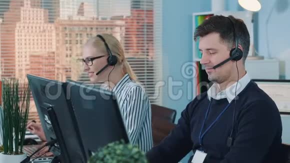 帅哥服务运营商在呼叫中心与客户电话交谈视频的预览图