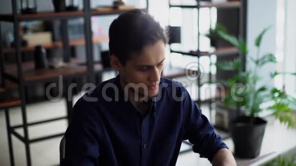 严肃的年轻商人在桌面上工作使用电脑的闲人视频的预览图