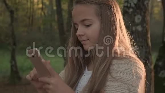 少女在公园里浏览智能手机视频的预览图